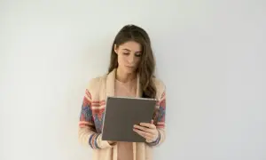 Kobieta w swetrze z kolorowym wzorem korzysta z tabletu, szukając informacji o l4 od psychiatry online.