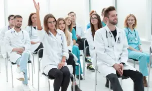 Uczestnicy kursu rejestratorka medyczna, jedna osoba podnosi rękę.
