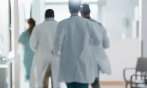 Lekarze w białych fartuchach spieszą korytarzem. Zastanawiasz się, ile zarabia lekarz?