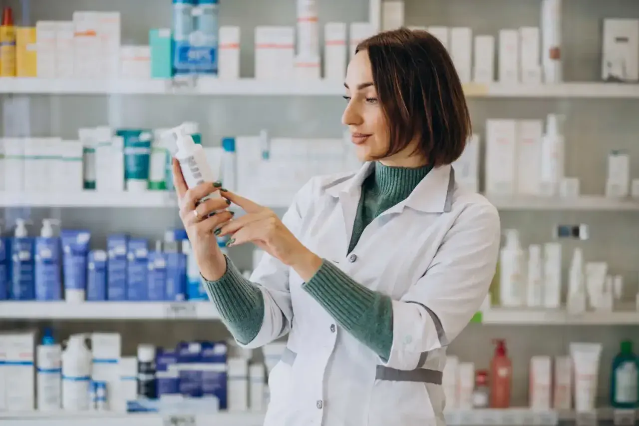 Farmaceutka w białym fartuchu analizuje skład leku, który może być wydany na receptę farmaceutyczną.