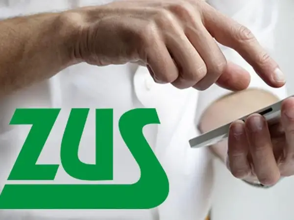 Dłonie trzymające smartfon na tle logo ZUS. Temat: umowa zlecenie a ciąża.